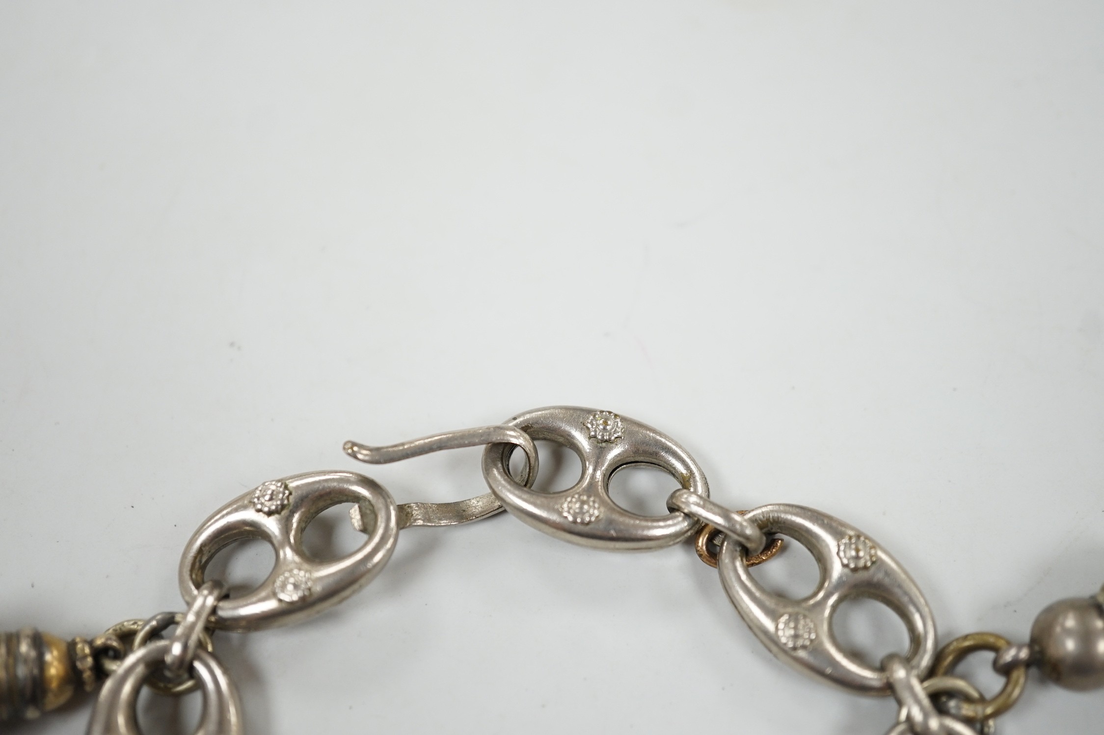 A white metal oval link bracelet, hung with three charms, including two fob seals, 21cm.